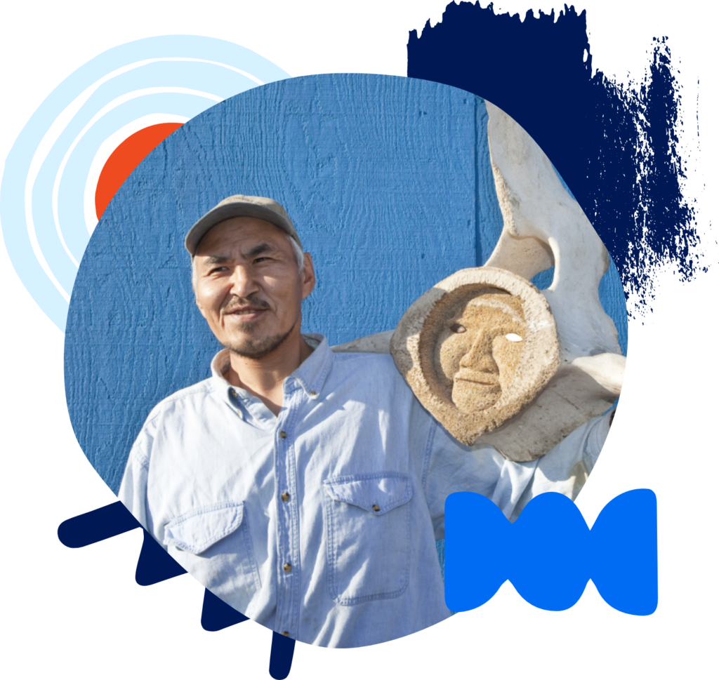Iñupiat man holding whale bone carving
